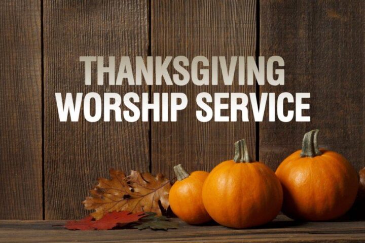 "Thanksgiving Worship Service" in white text in front of wooden plank panelling. orange pumpkins and leaves on wooden table